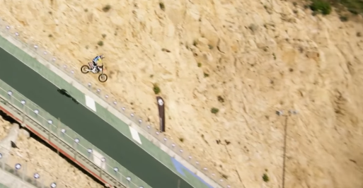 WATCH: Biker and bike washed down a flooded road